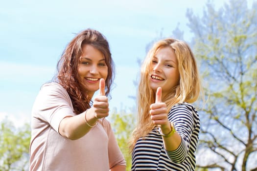 Two young women with thumbs up