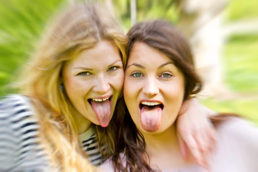 Two teenagers stick their tongue out