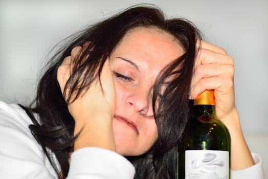 Young drunk woman with a bottle of red wine