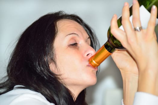 Young drunk woman with a bottle of red wine