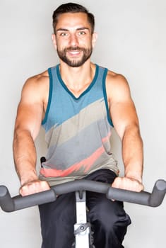 Young athletic man on training on the ergometer