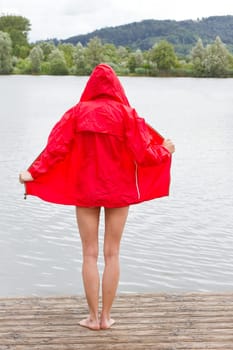 Young woman in red jacket at the lake