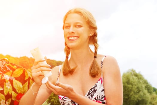 Applying young woman at sunscreen