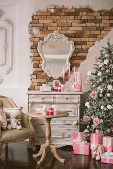 New Year's and Christmas interior in pink color with a dresser, a wall mirror, gifts, candles and a chair