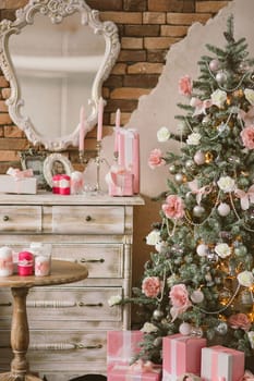 New Year's and Christmas interior in pink color with a dresser, a wall mirror, gifts, candles