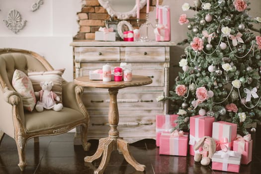 New Year's and Christmas interior in pink color with a dresser, a wall mirror, gifts, candles and a chair
