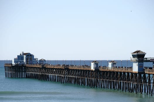 Oceanside,United States - December 25,2015: Visitors and tourists walk over Oceanside Pier in fine weather on December 25,2015 in Oceanside.