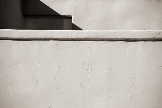 A smooth brick and plastered wall with a niche and a window.