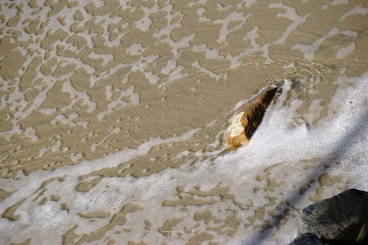 Seawater on the coast surrounds large boulders.