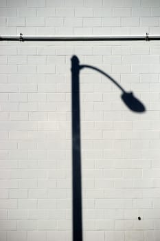 A distinctively curved lantern shadow on a brick wall.