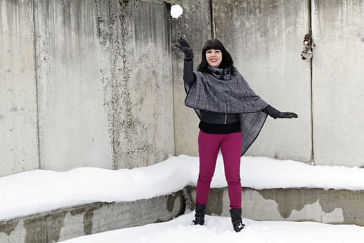 Fun in the snow - A young woman throws a snowball