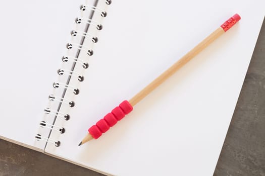 Blank notebook with pencil on grey background, business concept