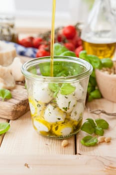 Mozzarella baellchen in olive noel and kraeutern in mason jar