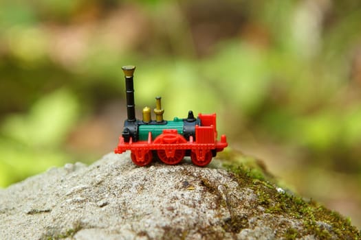 A little toy train put on a rock