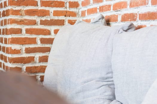 Grey pillow on a brick wall background, stock photo