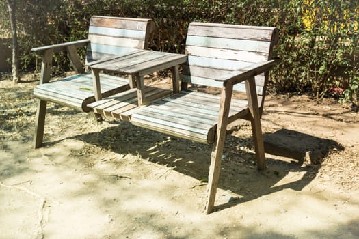 Double chairs standing in the garden with shadows, stock photo