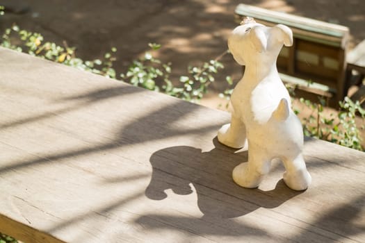 Dog plaster decorated wooden table with shadows