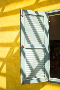 Window on yellow cement with shadows, stock photo