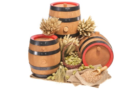 three old beer barrels insulated with wheat,barley,hops and malt On White