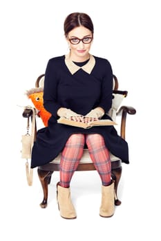 Studio shot of beautiful girl holding an open book on her lap.