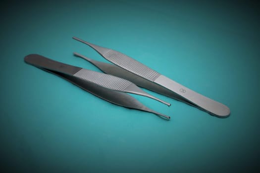 Two tweezers on a blue background