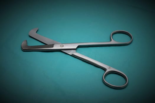 Umbilical cord scissors on a blue background