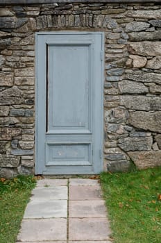 one old and grey door in the stone wall at Gunnebo castle