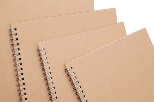 stack of spiral brown notebook on white background