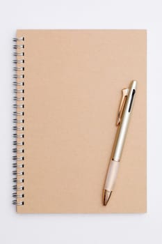 Blank spiral brown notebook with ball point pen