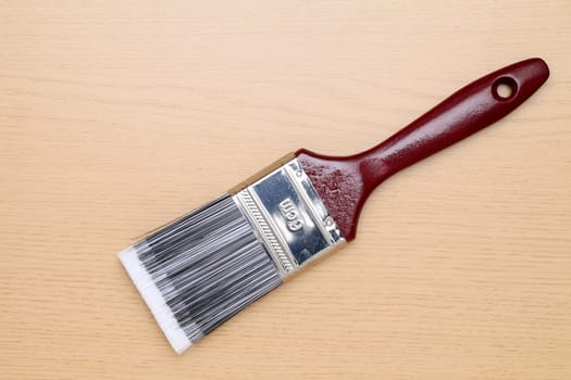 New paint brush on a wooden background