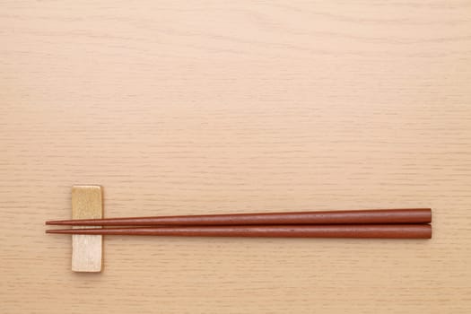 chopsticks and chopsticks rest on wooden table