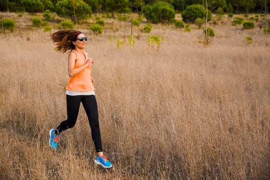 Shot of an attractive woman running outdoor on a meadow