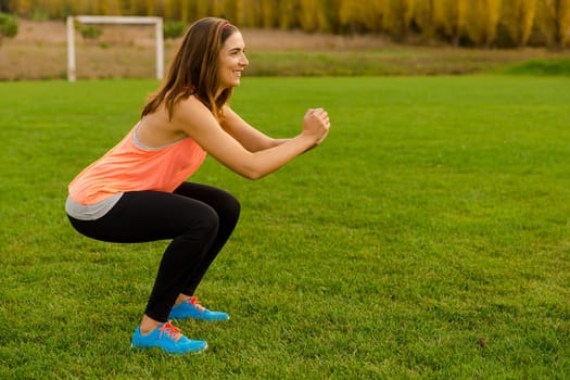 An attractive woman exercising outdoor on a soccer field
