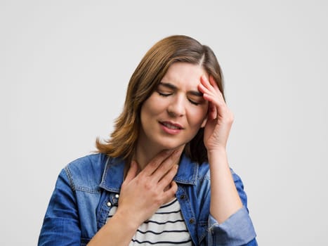Frustrated woman in pain with a sore throat