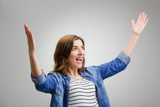 Studio portrait of a successful woman with arms raised