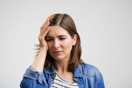 Portrait of a stressed woman holding head in hands