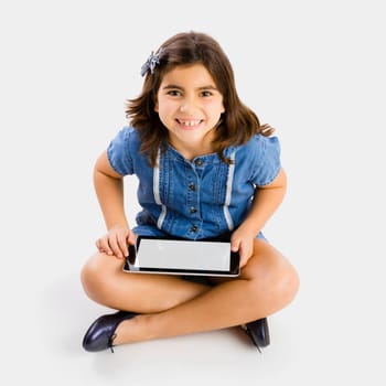 Young girl sitting on floor and using a tablet