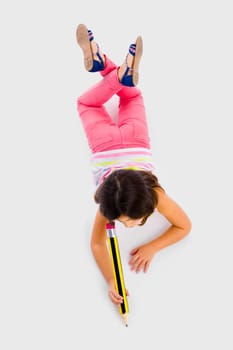Little girl making a drawing with a big pencil in the floor