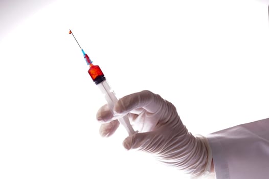 Hand with blood sample in syringe on white background