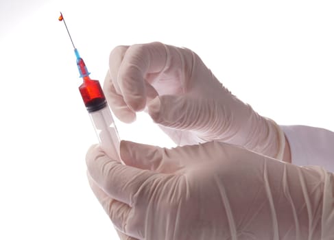 Hand with blood sample in syringe on white background
