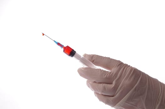 Hand with blood sample in syringe on white background