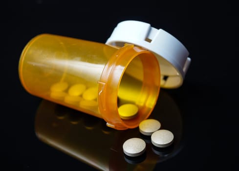 medicine pills lying on a black background