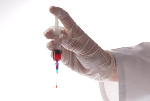 Hand with blood sample in syringe on white background