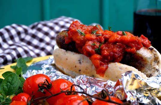 hotdog with bacon and tomato sauce and baked tomatoes