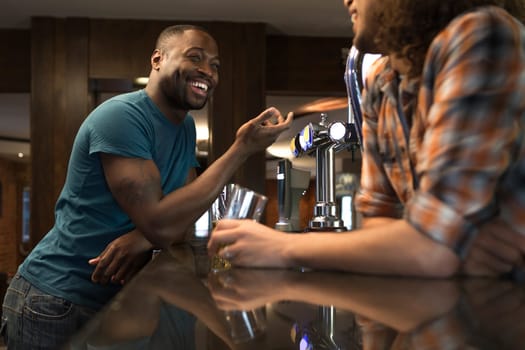 Young man standing at the bar talking to the bartender