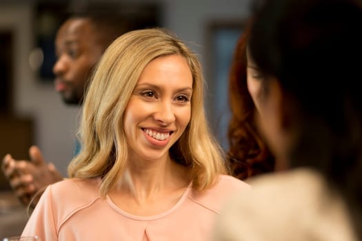 close up shot of a woman talking to her friends at a bar.