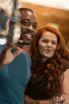 Young man waving to someone in a bar