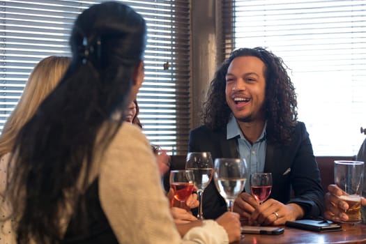 group of friends are drinking wine and beer, and talking in a bar.