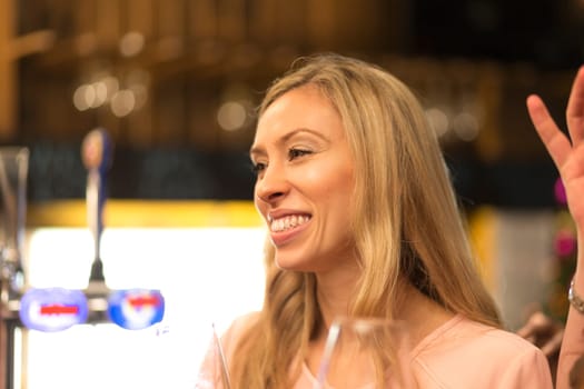 close up shot of a woman talking to her friends at a bar.