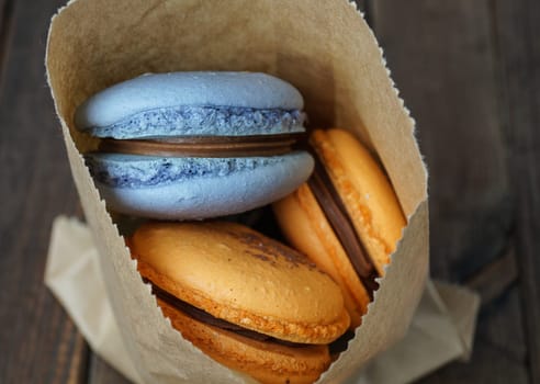 blue and orange macaroons in a backery paper bag